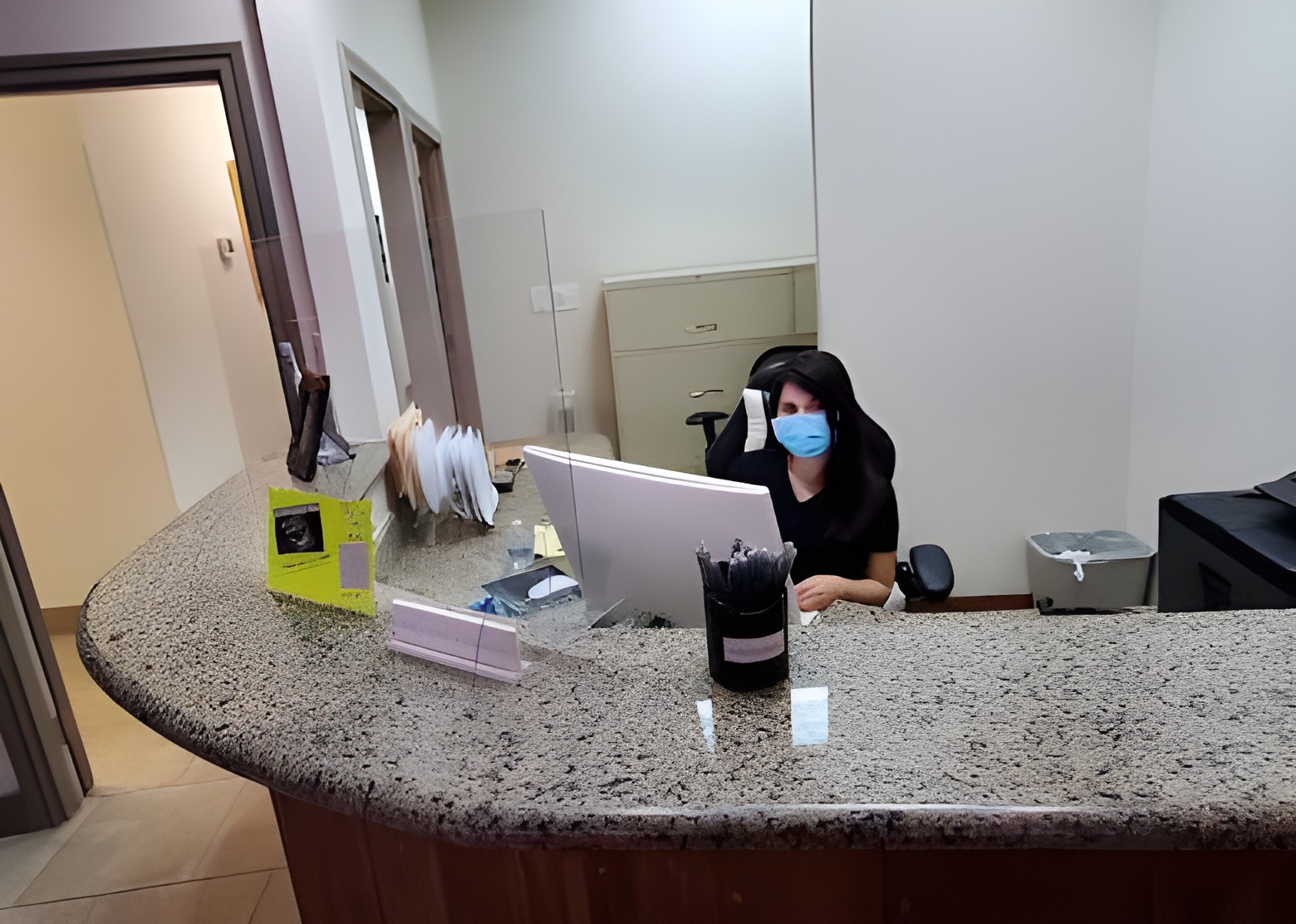 A team member behind the reception desk at the Gessner Road office