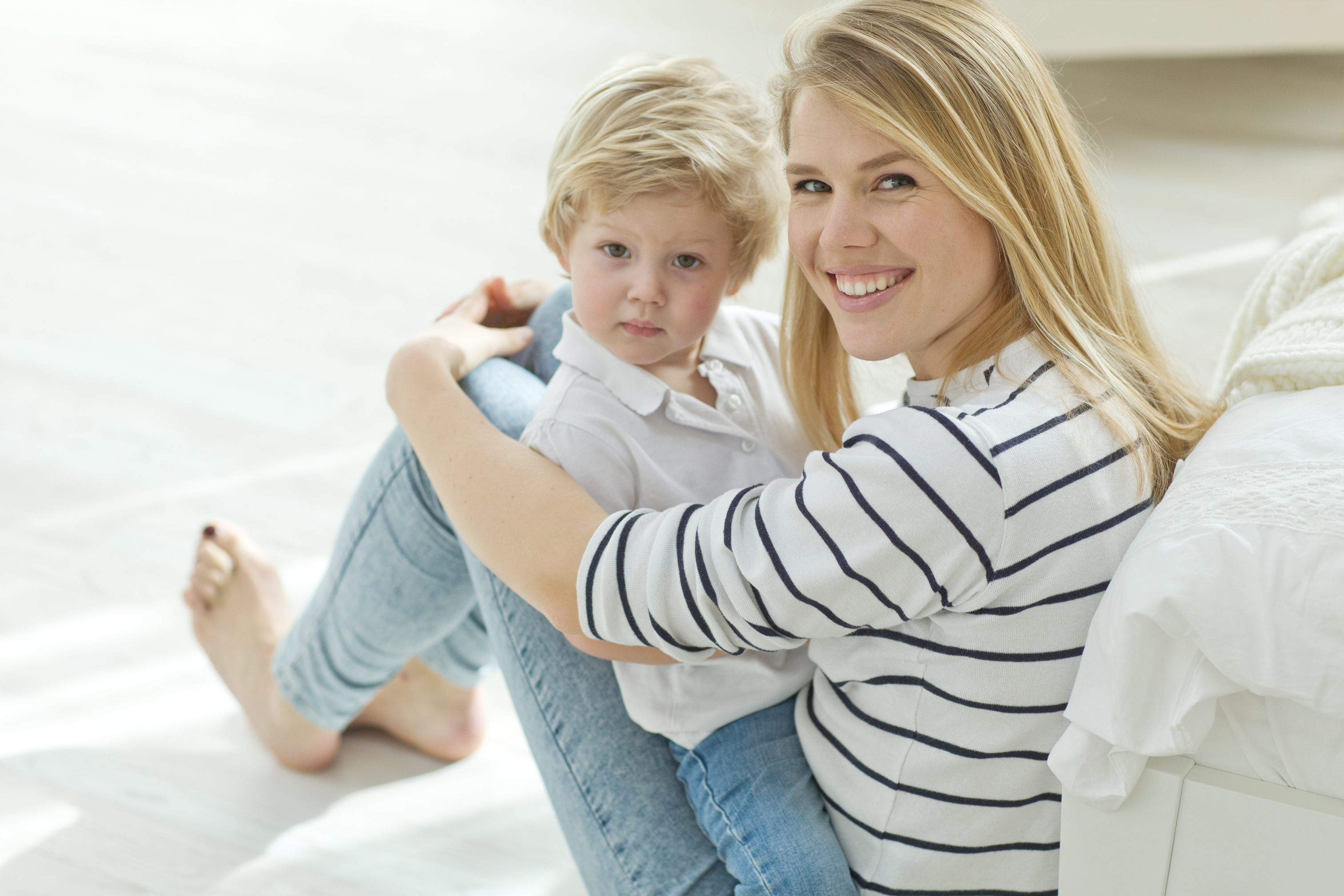 A smiling mother sitting with her young son