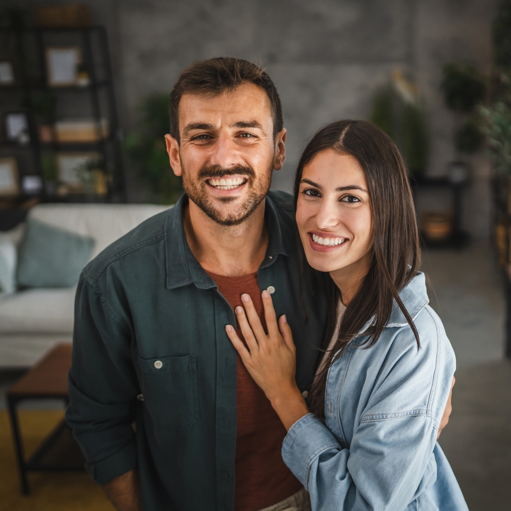 A smiling couple embracing at home