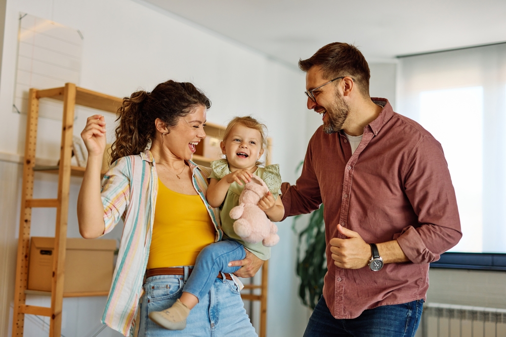 Parents laughing with their young daughter at home